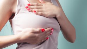 a woman with red nail polish holding her stomach